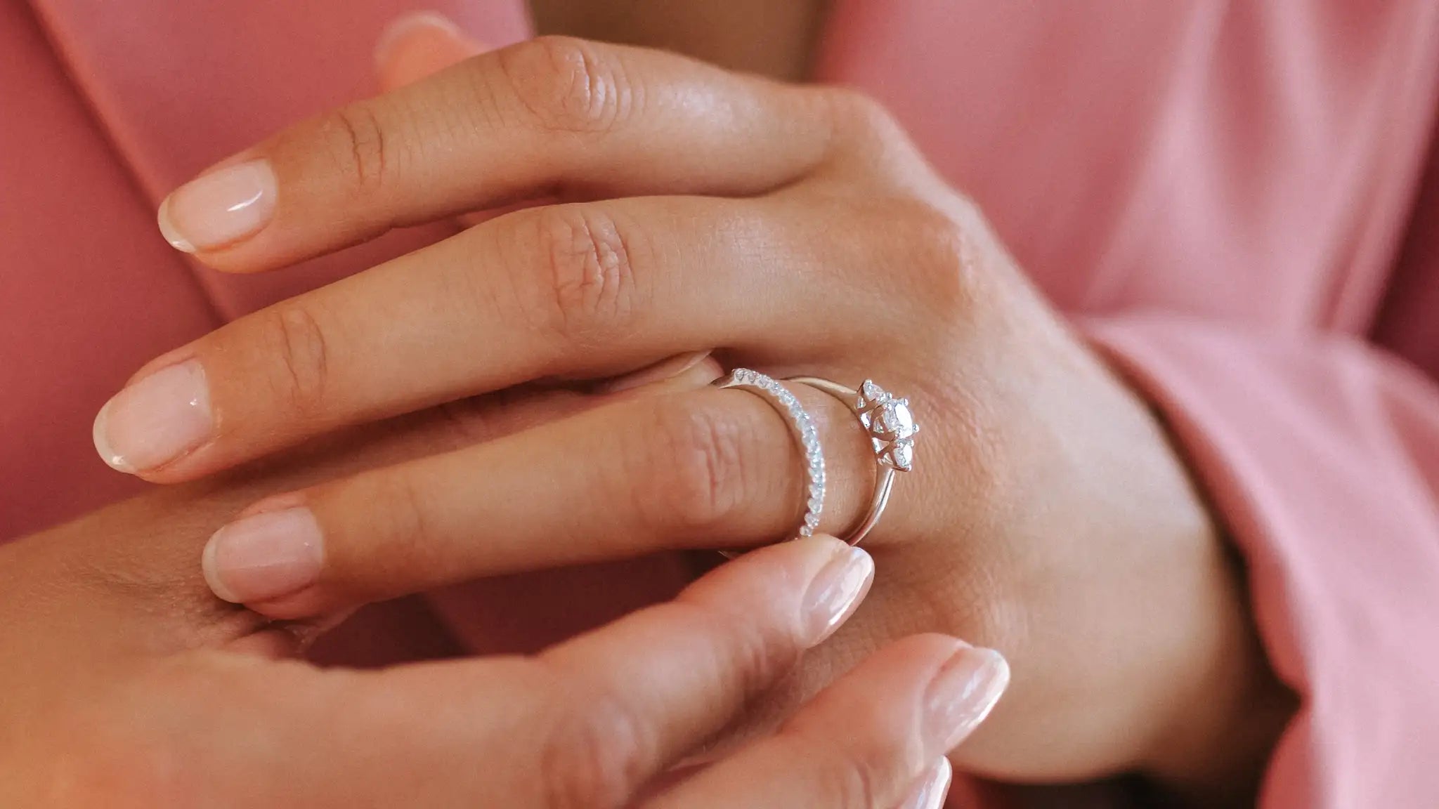 18 karaat gouden verlovingsring met lab grown diamant en trouwring worden tegen elkaar geschoven.